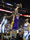 Los Angeles Lakers power forward Pau Gasol (16) shoots between New Orleans Hornets power forward Carl Landry, left, and point guard Greivis Vasquez (21) in the first half of an NBA basketball game in New Orleans, Monday, April 9, 2012. (AP Photo/Gerald Herbert)