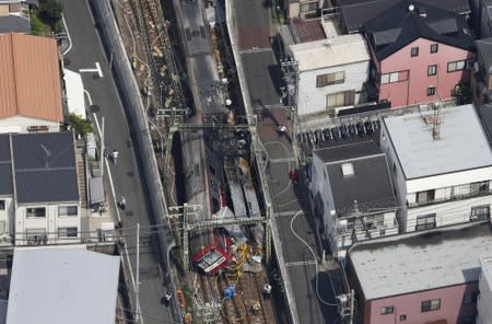 A train is seen as it is derailed after a collision with a truck in Yokohama