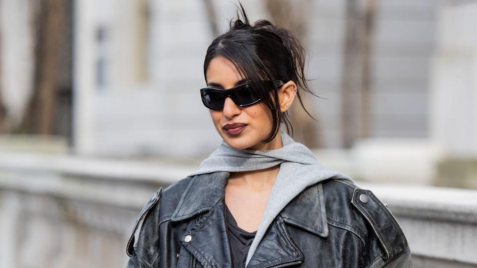 A guest wears oversized leather jacket, tights outside Coach's NYFW show