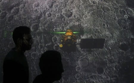 Student walk past a screen during a live streaming of Chandrayaan-2 landing at an educational institute in Mumbai