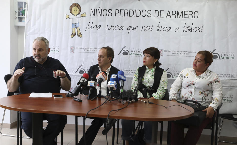 Doctor Juan Yunis, left, talks to the media as Francisco Gonzalez director of the Armando Armero Foundation, second left, Jenifer De La Rosa, second right, and Angela Rendon, left, listen during as press conference in Bogota, Colombia, Thursday, Nov. 14, 2019. The story of the lost sisters could be one of many involving children who were separated from their parents after the Nevado del Ruiz erupted, rescued from the rubble and later put up for adoption after no relative arrived to claim them . A genetic institute in Colombia's capital confirmed through DNA testing that Jenifer De La Rosa and Angela Rendon are sisters. (AP Photo/Fernando Vergara)