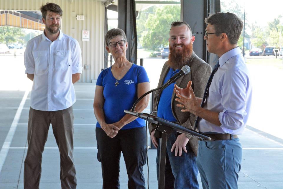 Adam Saunders, Columbia Center for Urban Agriculture capital campaign director, from left, and Boone County Commissioners Janet Thompson and Justin Aldred listen Thursday to Boone County Presiding Commissioner Kip Kendrick at the MU Health Care Pavilion in Clary-Shy Park as he extols the great work CCUA does for the community. The organization was awarded $1.5 million to go toward its welcome center next to the MU Health Care Pavilion, which is home to the Columbia Farmers Market.