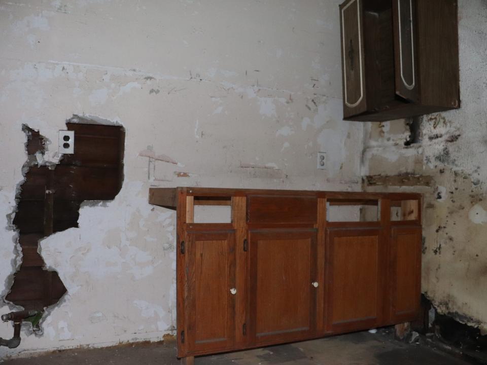An abandoned kitchen with fire and water damage.