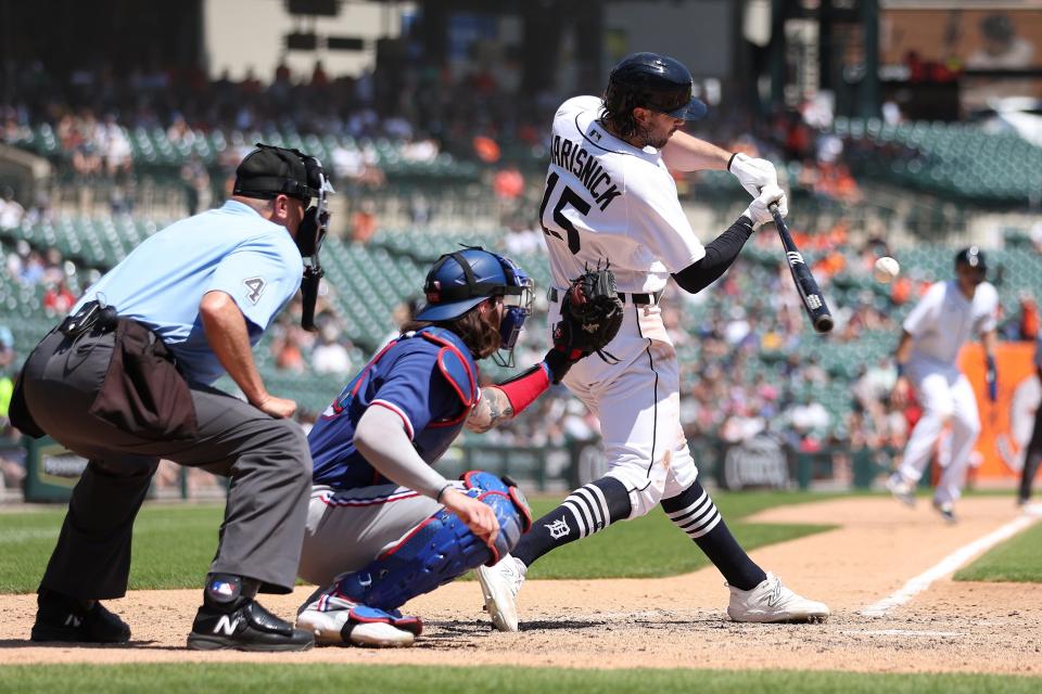 Jake Marisnick of the Detroit Tigers hits a sixth-inning RBI single in front of Jonah Heim of the Texas Rangers at Comerica Park on May 31, 2023 in Detroit, Michigan.