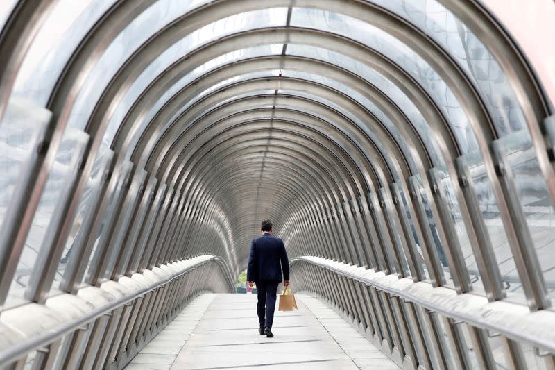 A businessman walks inside the Japan bridge at La Defense financial and business district in Puteaux