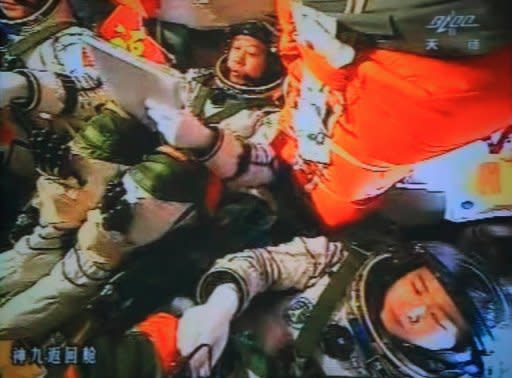 A photo of the giant screen at the Jiuquan space center shows three Chinese astronauts (from left) Liu Wang, Jing Haipeng and Liu Yang in the Shenzhou-9 spacecraft in the preparation for docking with the Tiangong-1 module on Monday. The three have entered an orbiting module for the first time, in a move broadcast live on China's state TV and a key step towards the nation's first space station