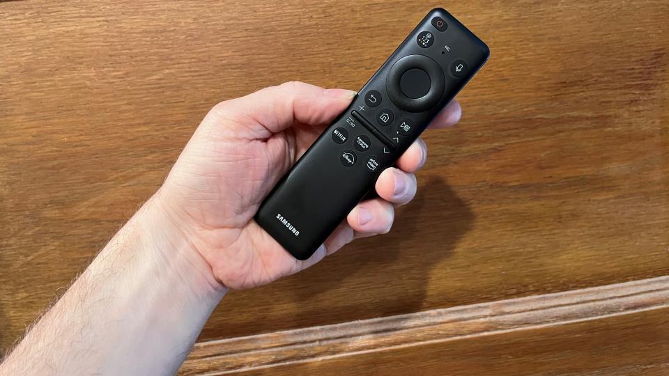 Samsung QN90C remote control held in hand