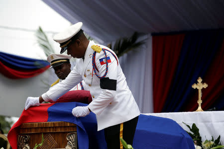 Members of the National Palace General Security Unit (USGPN) fix the Haiti National flag onto the coffin of Haiti's former President Rene Preval during his funeral in Port-au-Prince, Haiti, March 11, 2017. REUTERS/Andres Martinez Casares