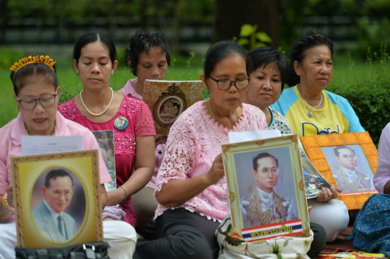 Thais hold portraits of King Bhumibol Adulyadej at Siriraj Hospital, where the 88-year-old king is being treated, in Bangkok on October 12, 2016