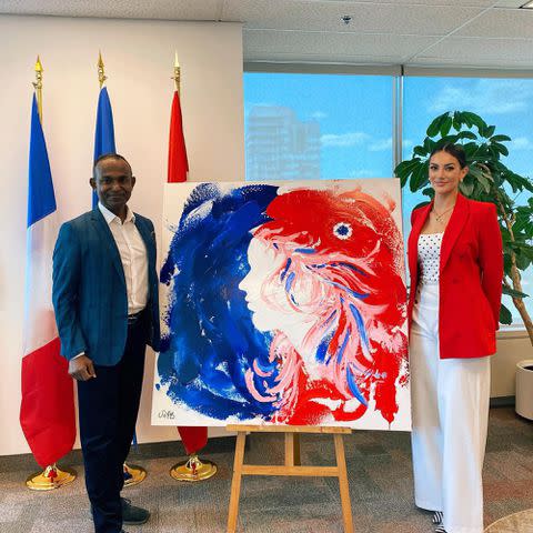 <p>Sophie Brussaux Insatgram</p> Sophie Brussaux and Tudor Alexis with a painting she drew for the French Consulate in Toronto in July 2021