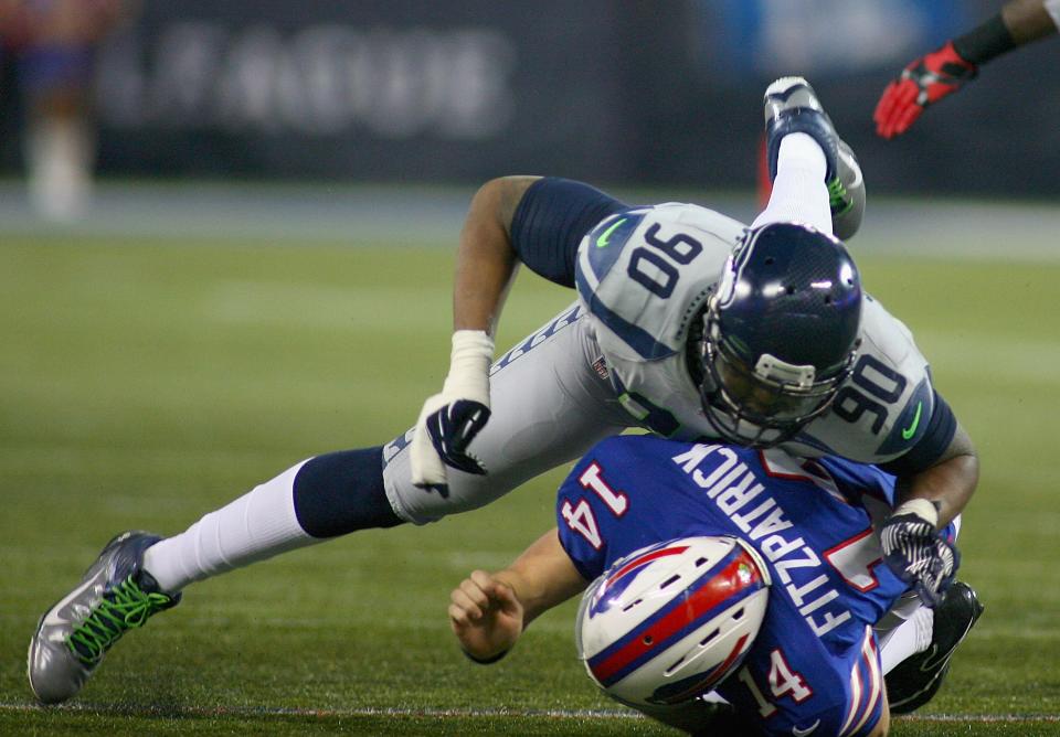 TORONTO, ON - DECEMBER 16: Jason Jones #90 of the Seattle Seahawks hits Ryan Fitzpatrick #14 of the Buffalo Bills at Rogers Centre on December 16, 2012 in Toronto, Ontario.Seattle won 50-17. Fitzpatrick was intercepted on the play. (Photo by Rick Stewart/Getty Images)