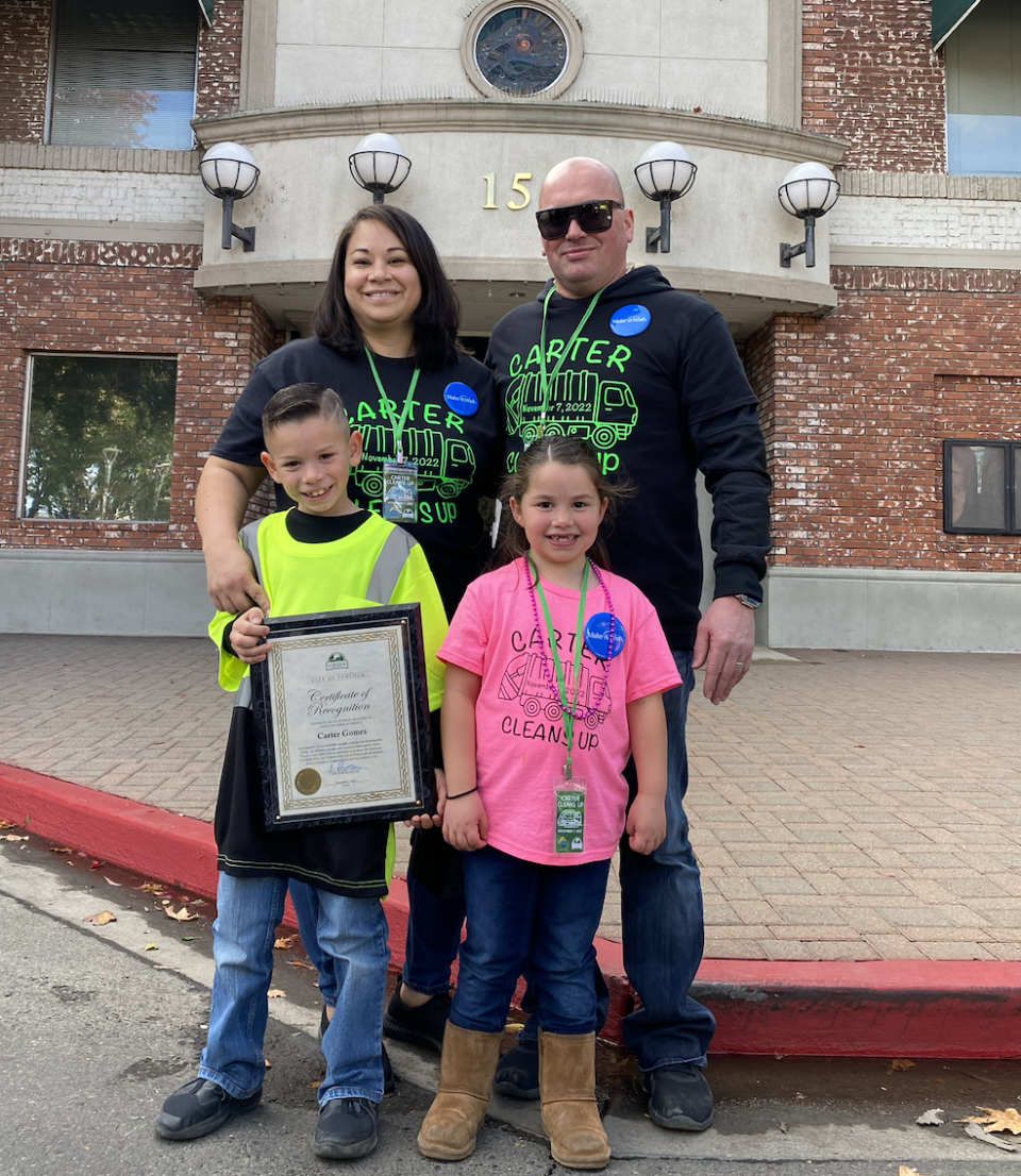 Carter Gomes, 7, poses with his family on Nov. 7 as the Make-A-Wish Foundation granted him his wish of becoming a garbage man for a day in Turlock, California.