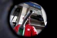 A man points a fuel nozzle at the camera for a photograph at a gas station belonging to Venezuelan state oil company PDVSA in Caracas, Venezuela July 21, 2016. Picture taken July 21, 2016. REUTERS/Carlos Jasso