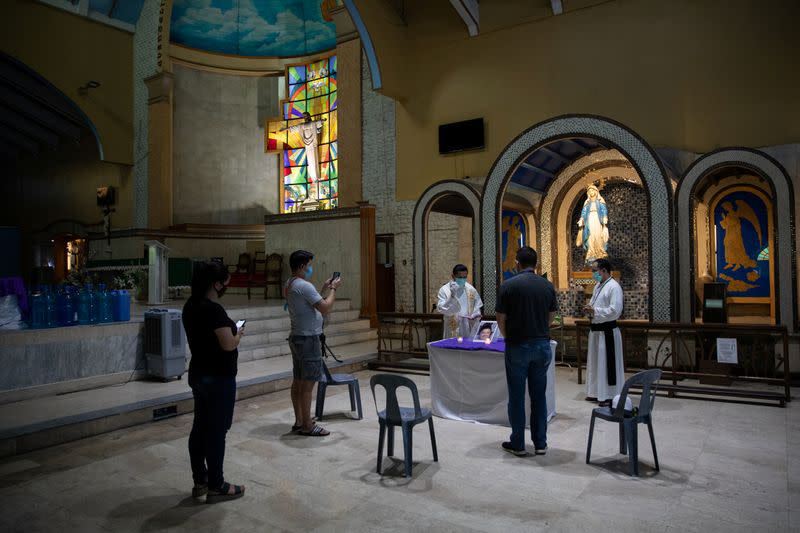 The Wider Image: Hazmat suits and holy water: two priests bring faith to Philippines lockdown