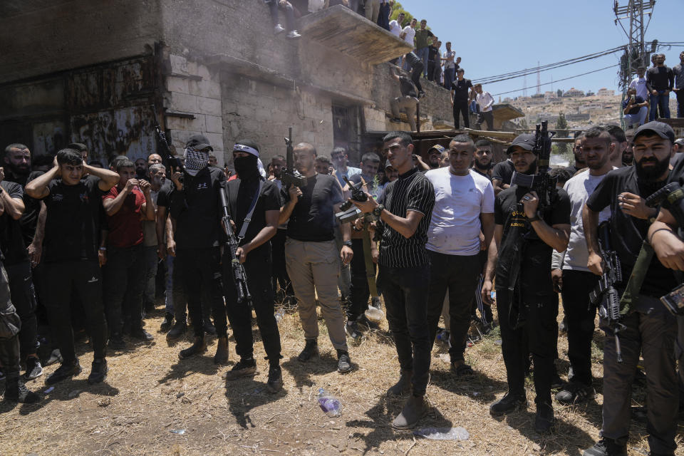Palestinian gunmen shoot in the air during the funeral of those who were killed during an Israeli army operation, in the Jenin refugee camp, West Bank, Wednesday, July 5, 2023. The Israeli military says it withdrew its troops from the camp on Wednesday, ending an intense two-day operation that killed at least 13 Palestinians, drove thousands of people from their homes and left a wide swath of damage in its wake. One Israeli soldier was also killed. (AP Photo/Majdi Mohammed)
