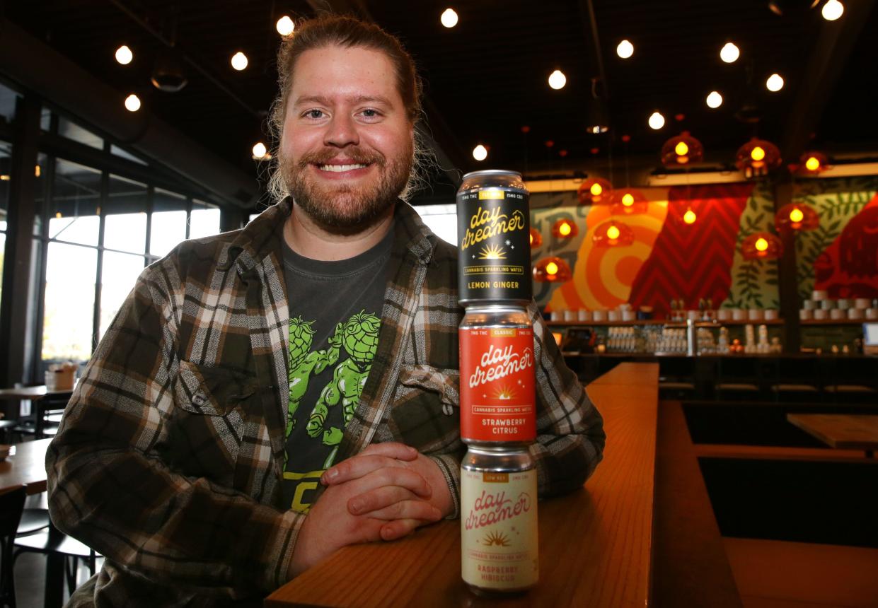 Alec Travis, head of brewery operations at Field Day Brewing Co., with three flavors and strengths of the North Liberty brewery's THC beverage. He'll need to make some adjustments but says the product remains viable under a new Iowa law.