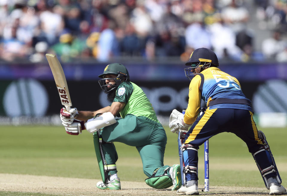 South Africa's batsman Hashim Amla, left, watches his shot as Sri Lanka's wicketkeeper Kusal Perera looks on during the Cricket World Cup match between Sri Lanka and South Africa at the Riverside Ground in Chester-le-Street, England, Friday, June 28, 2019. (AP Photo/Scott Heppell)