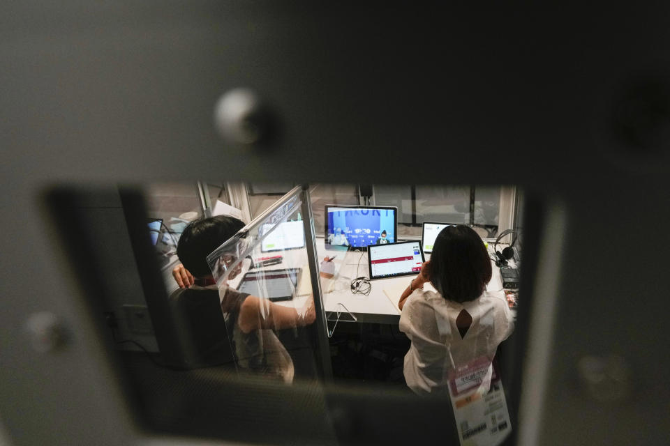 Interpreters work at the main press center during the 2020 Summer Olympics, Friday, July 30, 2021, in Tokyo, Japan. Unlike previous Olympics, all the interpretation is being done remotely with most interpreters working in booths at the main center. About two dozens interpreters aren't even in the country, chiming in from the Americas or Europe to handle late night events in Japan. (AP Photo/Luca Bruno)