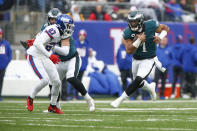 Philadelphia Eagles quarterback Jalen Hurts, right, runs the ball during the first half of an NFL football game against the New York Giants, Sunday, Nov. 28, 2021, in East Rutherford, N.J. (AP Photo/John Munson)