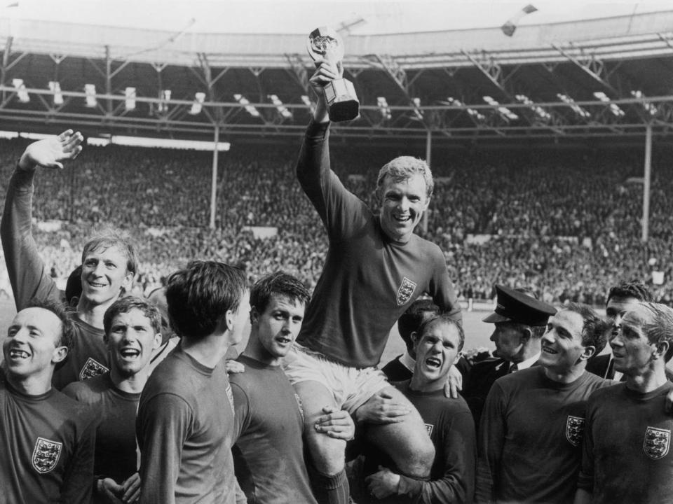 Bobby Moore holding aloft the Jules Rimet trophy as he is carried by his teammates following England’s victory over Germany in the 1966 World Cup final (Getty)