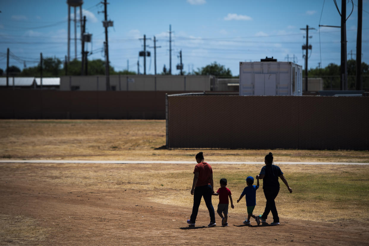 Immigrant women and children walk across a field as Immigration and Customs Enforcement and Enforcement and Removal Operations host a media tour at the South Texas Family Residential Center last summer in Dilley, Texas. (Photo: Jabin Botsford/The Washington Post via Getty Images)