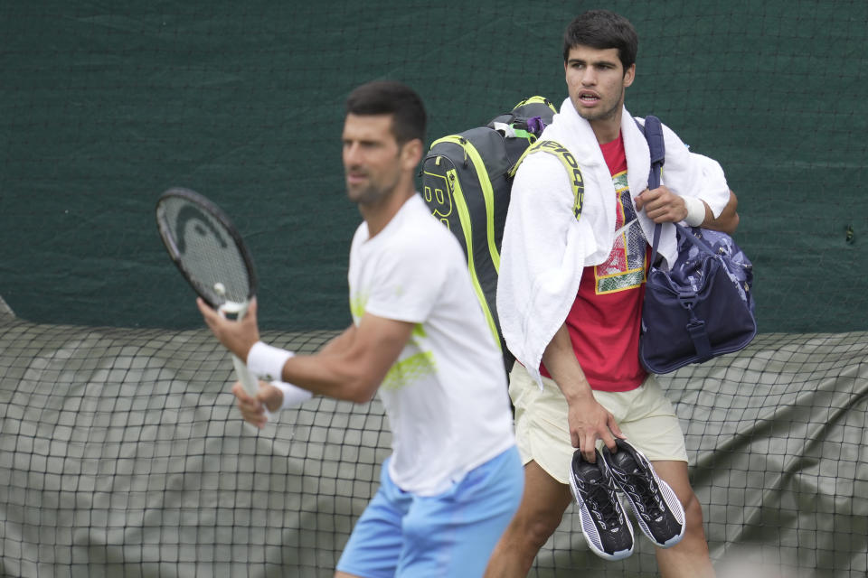 Novak Djokovic of Serbia, left and Carlos Alcaraz of Spain take part in a practice session ahead of the Wimbledon tennis championships at Wimbledon, in London, Sunday, July 2, 2023. The Wimbledon Tennis championships start on July 3. (AP Photo/Kin Cheung)