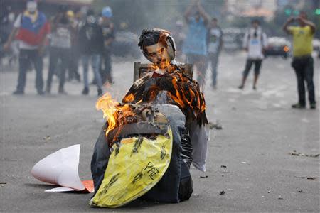 Anti-government protesters burn an effigy depicting Venezuela's President Nicolas Maduro in Caracas April 20, 2014. REUTERS/Jorge Silva