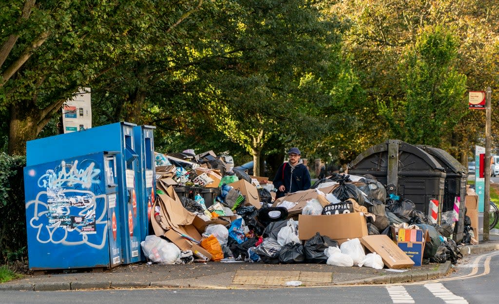 A man picks his way through the growing mountain of rubbish in Montpellier Terrace as the Brighton bin strike continues. (Getty Images)