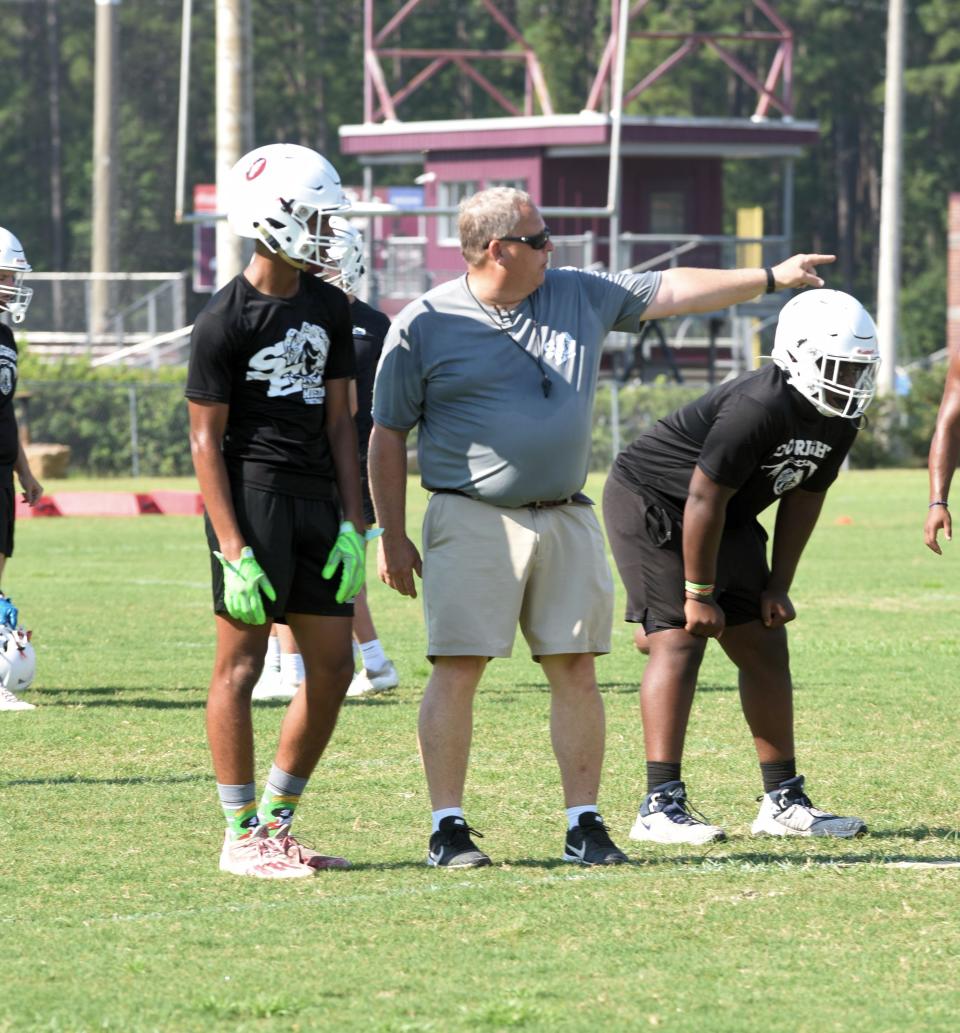 South Effingham High School assistant head coach and running backs coach Pat Collins points to where the player should be in the tight end cross play at a recent practice.