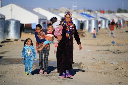 Civilians who fled from Diyala province walk at refugee camp in Khanaqin city, February 6, 2015. REUTERS/Ahmad Mousa