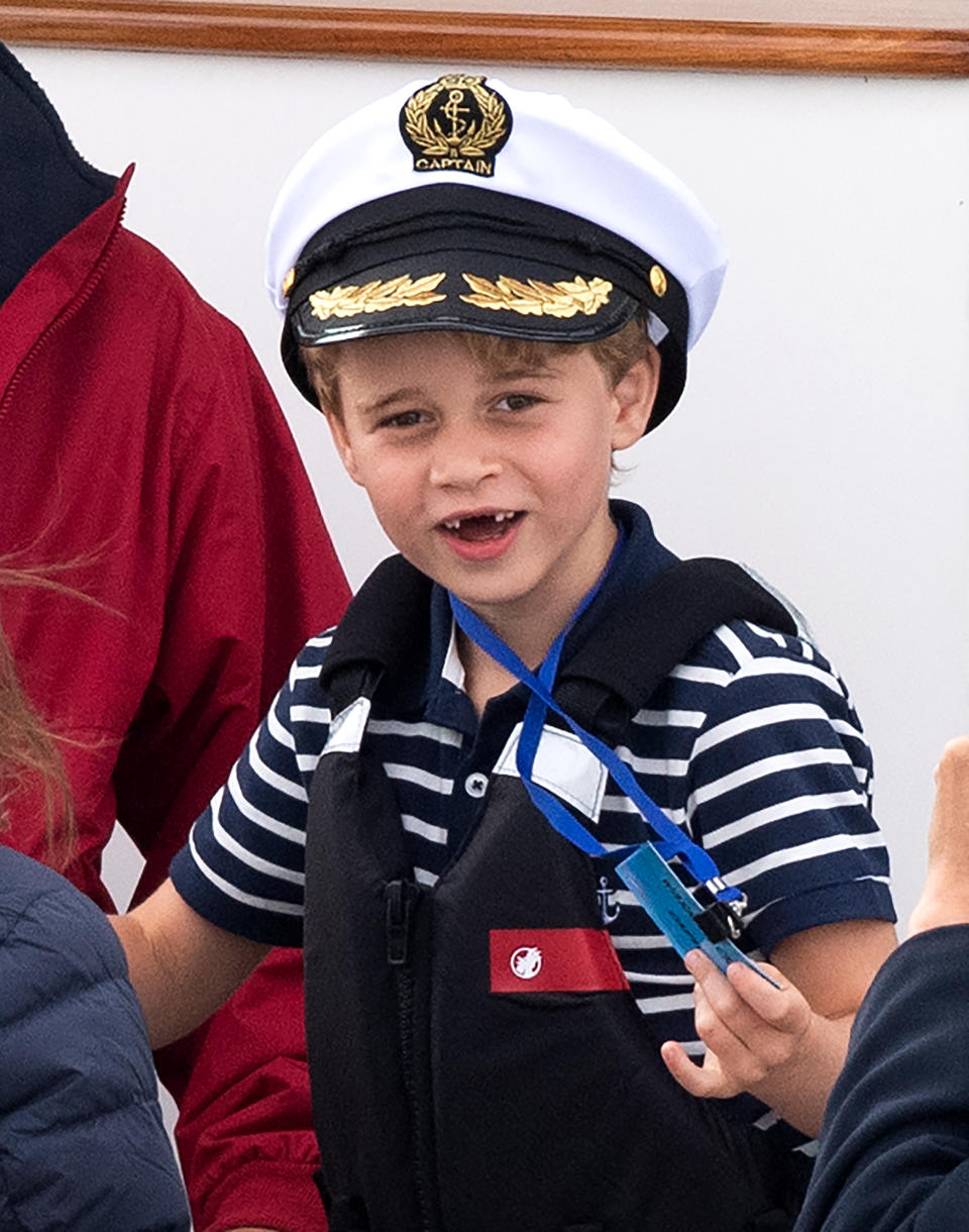 Prince George, with missing front teeth and wearing a Captain's cap, watches the inaugural King's Cup regatta, hosted by the Duke and Duchess of Cambridge, 