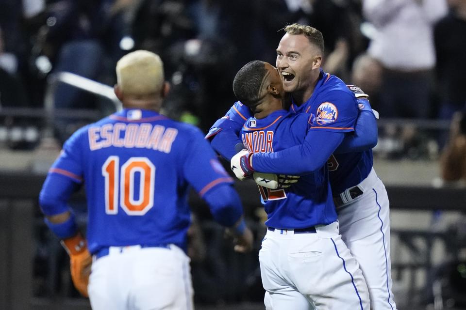 New York Mets' Francisco Lindor, center, hungs Brandon Nimmo, right, after Nimmo drove in the winning run with a double during the 10th inning of the team's baseball game against the New York Yankees on Wednesday, June 14, 2023, in New York. (AP Photo/Frank Franklin II)