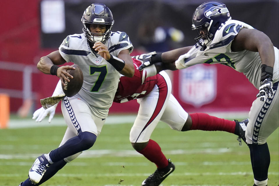 Seattle Seahawks quarterback Geno Smith (7) tackles the Arizona Cardinals during the first half of an NFL football game in Glendale, Ariz., Sunday, Nov. 6, 2022. (AP Photo/Ross D. Franklin)