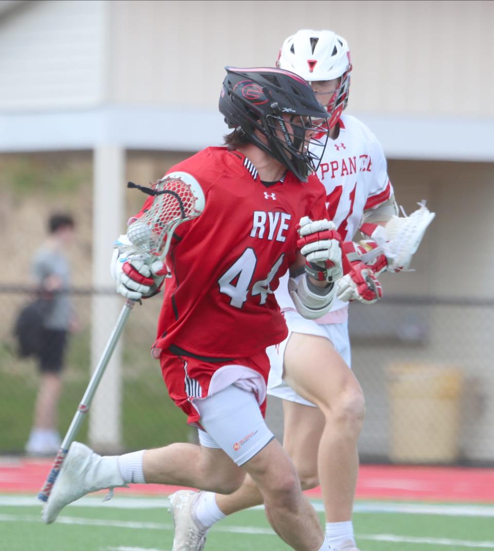 Rye midfielder Johnny Hartzell (44) works against Tappan Zee midfielder Thomas Kennedy (11) during their 14-8 win over Tappan Zee in boys lacrosse action at Tappan Zee High School in Orangeburg on Tuesday, April 12, 2022.