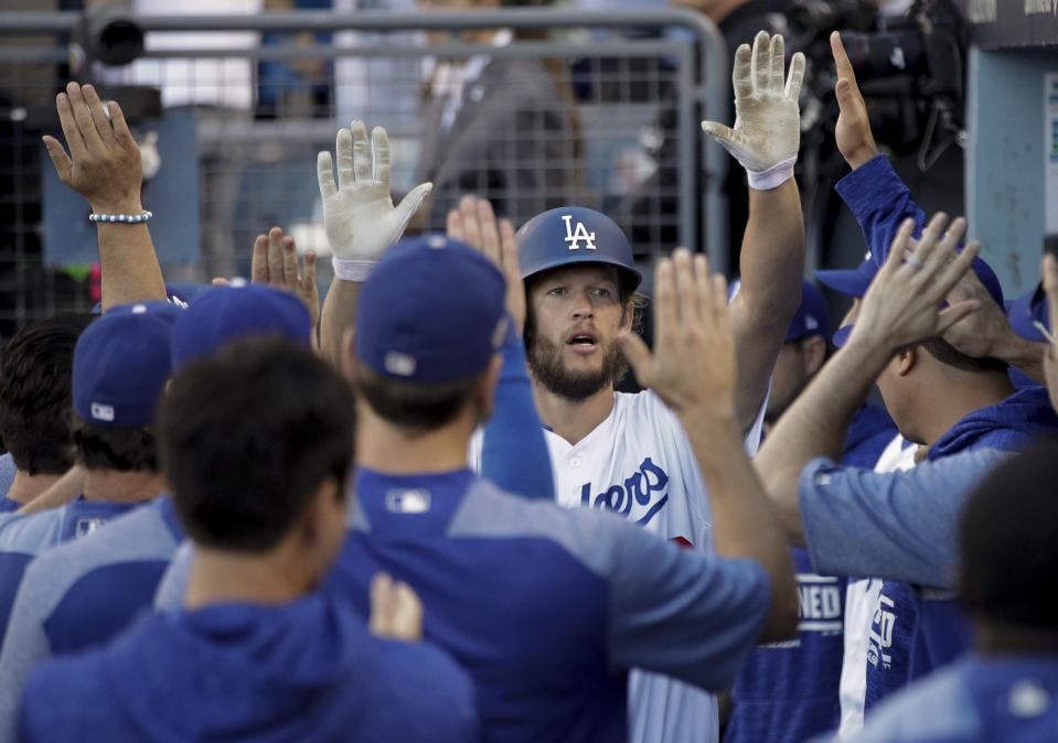 Los Angeles Dodgers' Clayton Kershaw is congratulated after scoring a run during the seventh inning of Game 5 of the National League Championship Series baseball game against the Milwaukee Brewers Wednesday, Oct. 17, 2018, in Los Angeles. (AP Photo/Jae Hong)