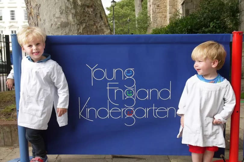 Kids beside sign of school