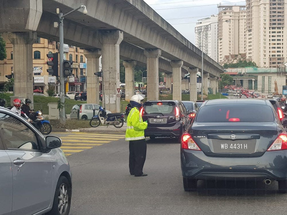 Based on his clothing, the man does not appear to be an official traffic policeman but he willingly offered his services anyway. — Picture from Facebook/Danny Liew