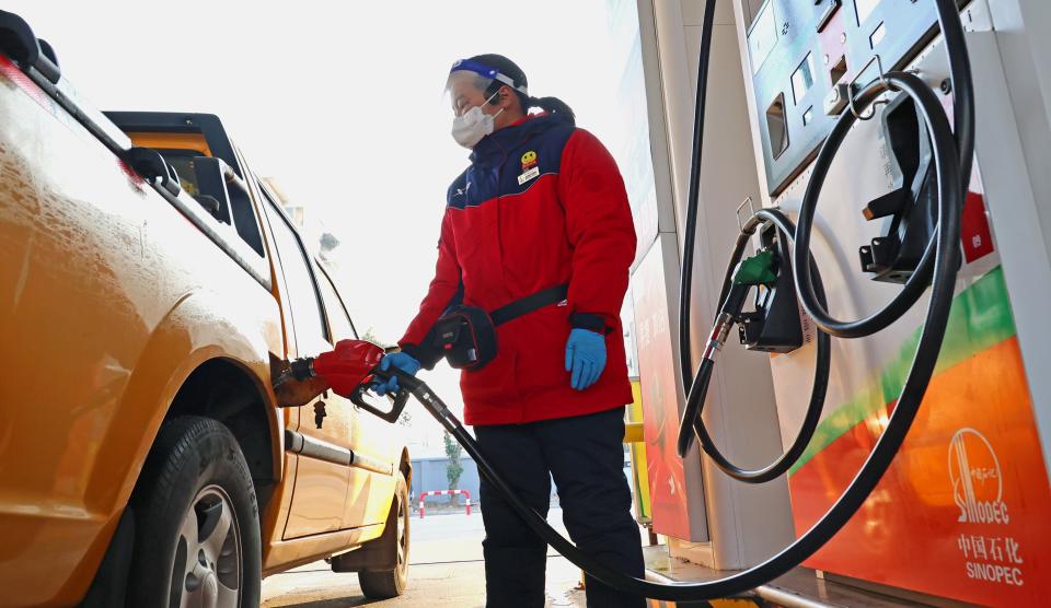 Un membro del personale fa rifornimento di carburante a un'auto in una stazione di servizio nel distretto di Haizhou di Lianyungang, nella provincia di Jiangsu, nella Cina orientale, 17 gennaio 2023. La Cina ridurrà i prezzi al dettaglio di benzina e diesel da mercoledì, sulla base dei recenti cambiamenti nei prezzi internazionali del petrolio, ha detto martedì il principale pianificatore economico del paese. I prezzi della benzina e del diesel scenderanno di 205 yuan, circa 30 dollari USA per tonnellata e 195 yuan per tonnellata, rispettivamente, ha affermato la Commissione nazionale per lo sviluppo e la riforma. (Foto di Geng Yuhe/Xinhua via Getty Images)