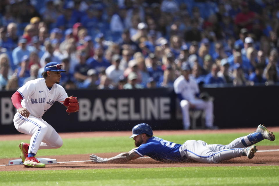 Kansas City Royals center fielder Kyle Isbel slides into third base with a triple ahead of the tag of Toronto Blue Jays third baseman Santiago Espinal during the sixth inning of a baseball game in Toronto on Sunday, Sept. 10, 2023. (Nathan Denette/The Canadian Press via AP)