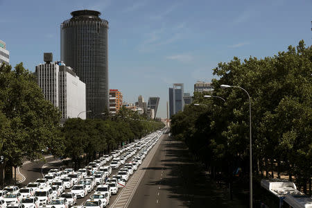 Parked taxis block a section of Paseo de la Castellana, one of Madrid's main avenues, during a strike against what they say is unfair competition from ride-hailing and car-sharing services such as Uber and Cabify in Madrid, Spain, July 30, 2018. REUTERS/Susana Vera