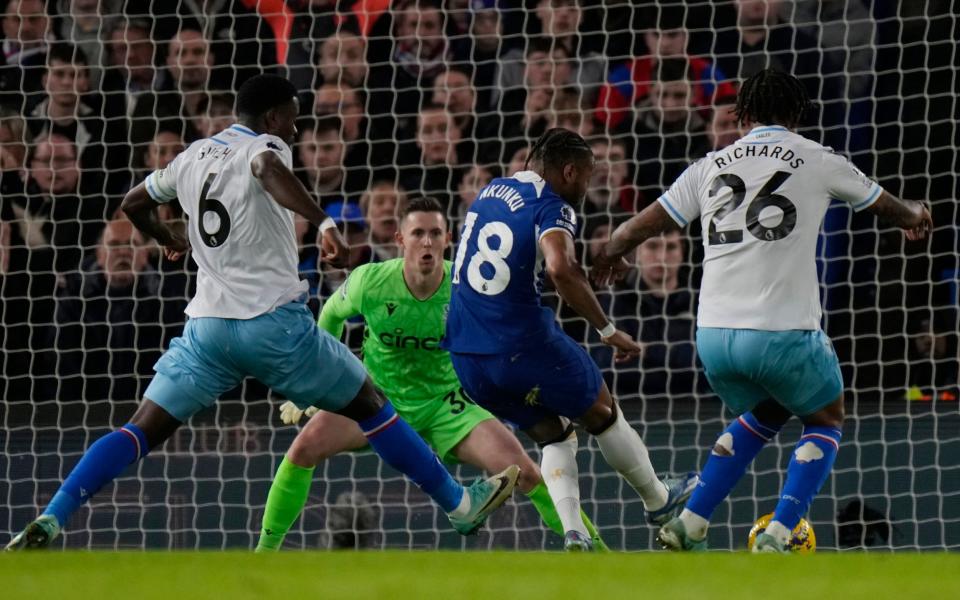 Christopher Nkunku falls over in front of goal after accidentally kicking Chris Richards