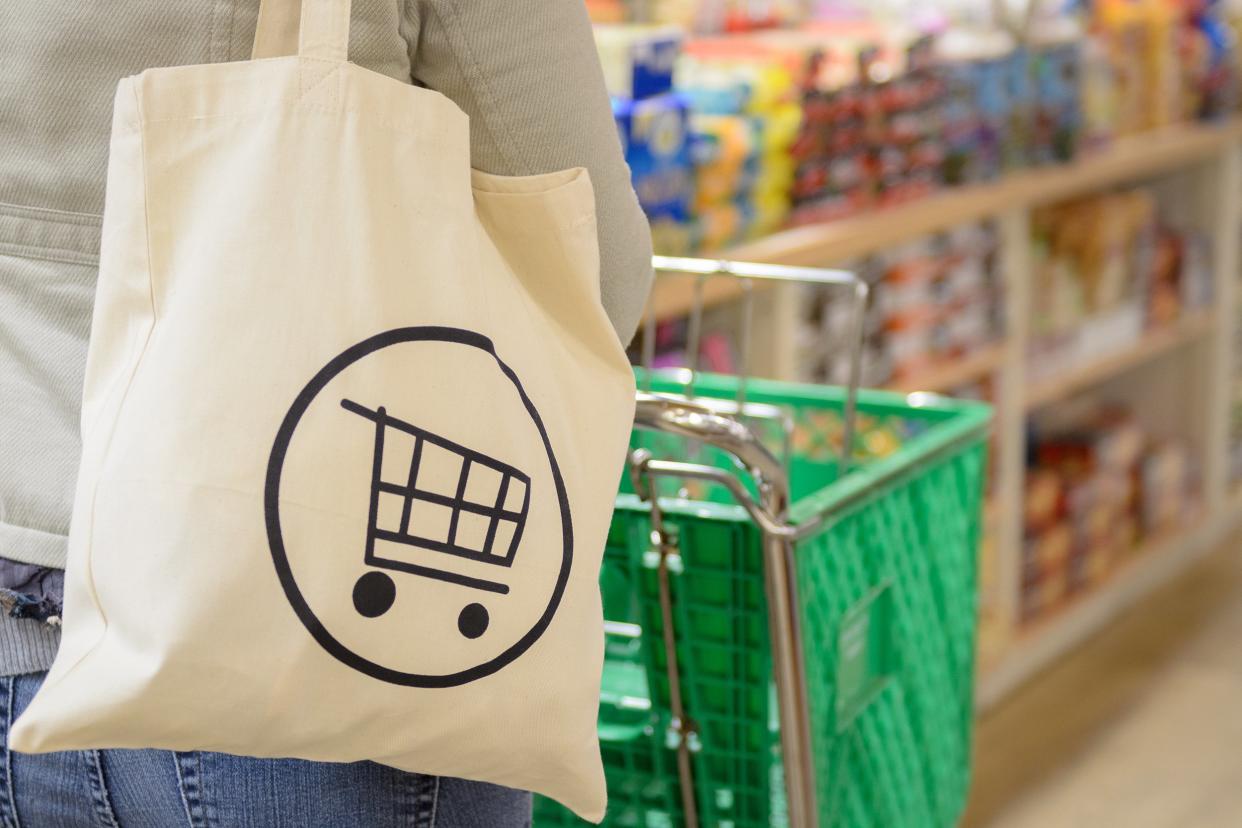 Woman holding a reusable grocery bag shopping in the supermarket