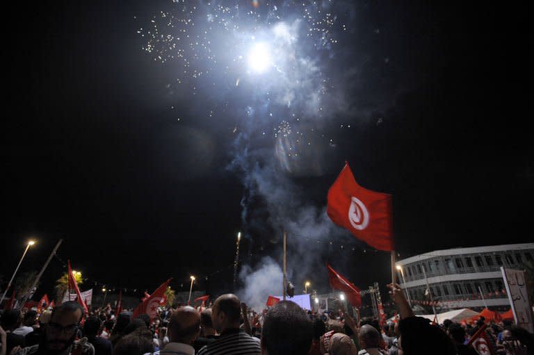 Tunisian people with flags chant slogans in front of the National Constituent Assembly on August 6, 2013 in Tunis. More than 40,000 people gathered to demand the resignation of the government led by the moderate Islamic movement Ennahda