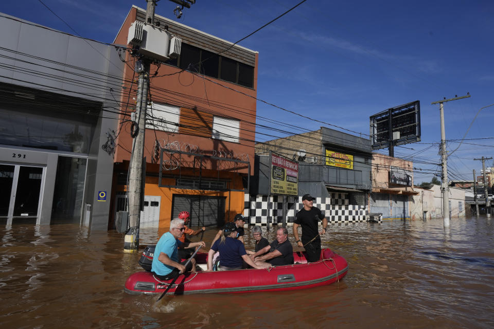 Volunteers evacuate residents from an area flooded by heavy rains, in Porto Alegre, Brazil, Tuesday, May 7, 2024. (AP Photo/Andre Penner)