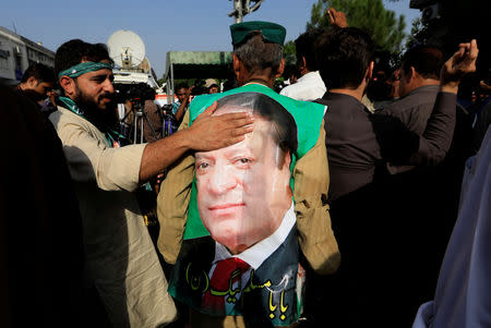 A supporter of former Prime Minister Nawaz Sharif touches his picture as he celebrate with others following the court's decision in Islamabad, Pakistan September 19, 2018. REUTERS/Faisal Mahmood