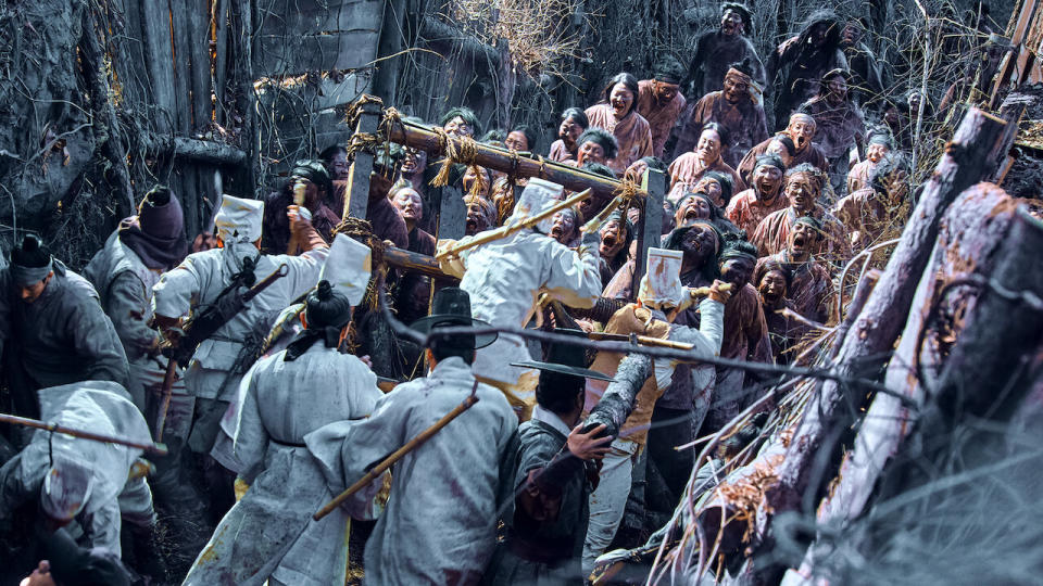 A still from Kingdom shows people in Joseon era Korea being overtake by zombies 