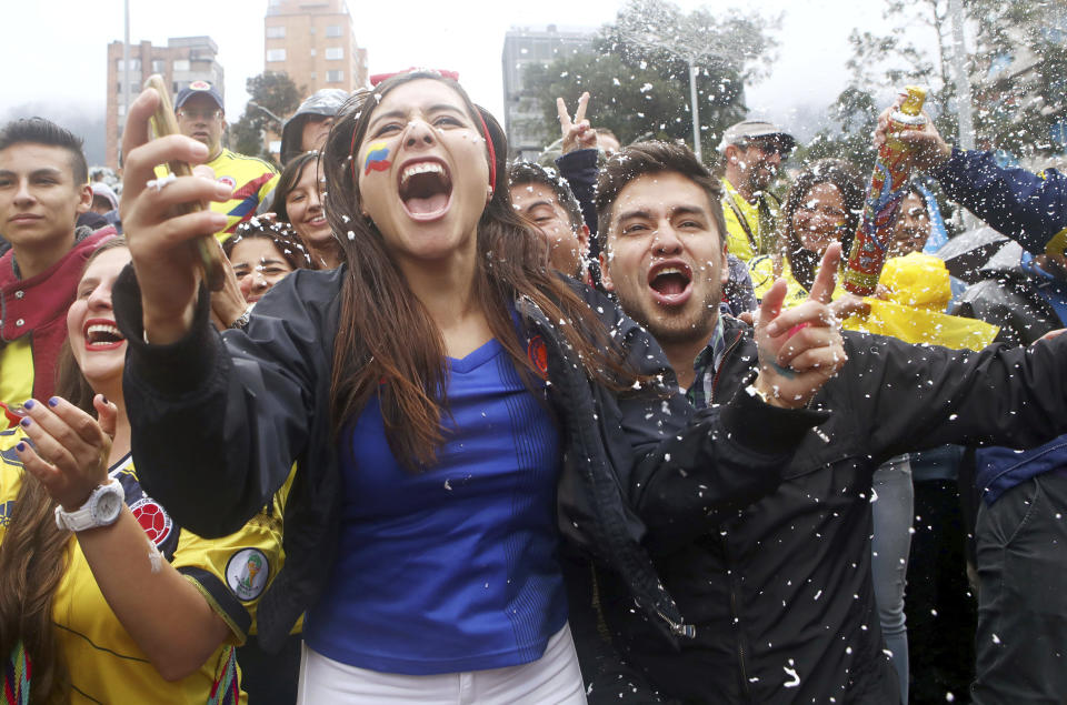 <p>Colombian fans watching the match in Bogota celebrate after their side topped Group H </p>