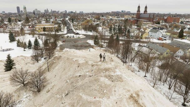 PHOTO: Residents take in the view from atop a gigantic snow pile in front of Central Terminal in Buffalo, New York Dec. 29, 2022. (Joed Viera/AFP via Getty Images)