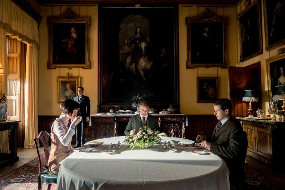 michelle dockery, hugh bonneville and allen leech sitting at a breakfast table on the set of the new downton abbey movie