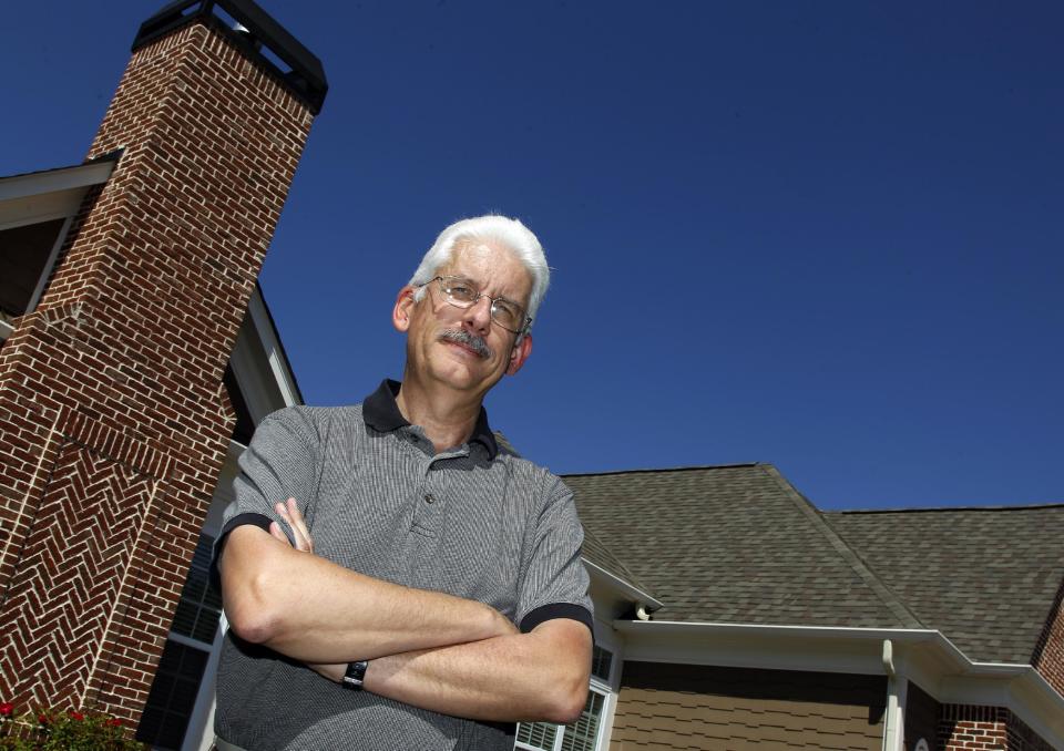 In this photo taken Monday, April 9, 2012, David Dobs poses in front of his home in Cumming, Ga. Dobs' home owners' association denied his request to install solar panels on his roof. Georgia lawmakers narrowly defeated a bill this year that would have prevented homeowners associations from banning solar panels. (AP Photo/John Bazemore)